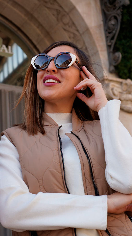 Mujer con gafas de sol de la coleccion Esencia mediterraneo, las gafas son octogonales, grandes, patillas difuminadas en marron y negro