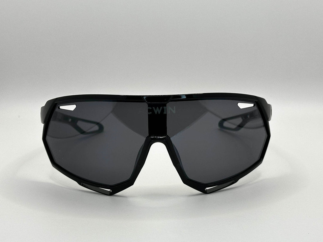 Vista frontal de las gafas deportivas SELVA con montura marrón y lente gris ahumado.