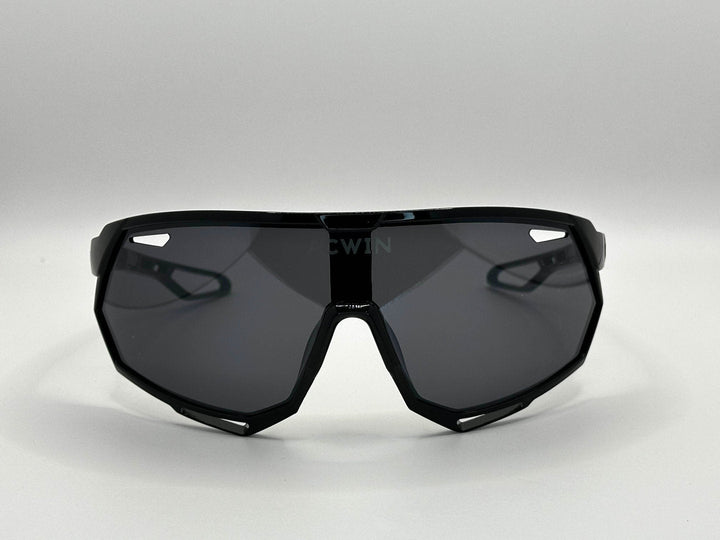 Vista frontal de las gafas deportivas SELVA con montura marrón y lente gris ahumado.