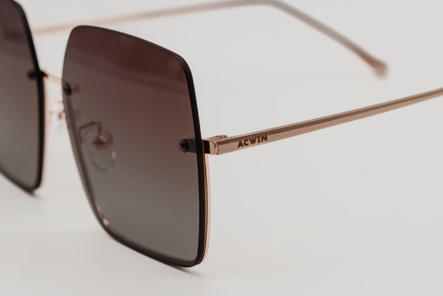 Detalle macro de la sujeción de la lente y varilla dorada con logo del modelo Hong Kong.