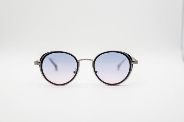 Vista en perspectiva gafas de sol Paris redondas con lentes degradadas azul y rosa.